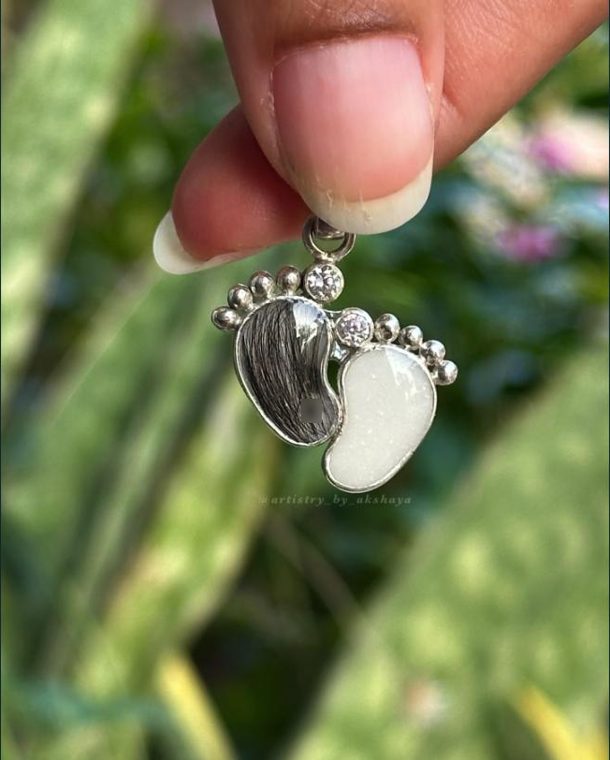 Silver baby footprint pendant holding first hair and milk